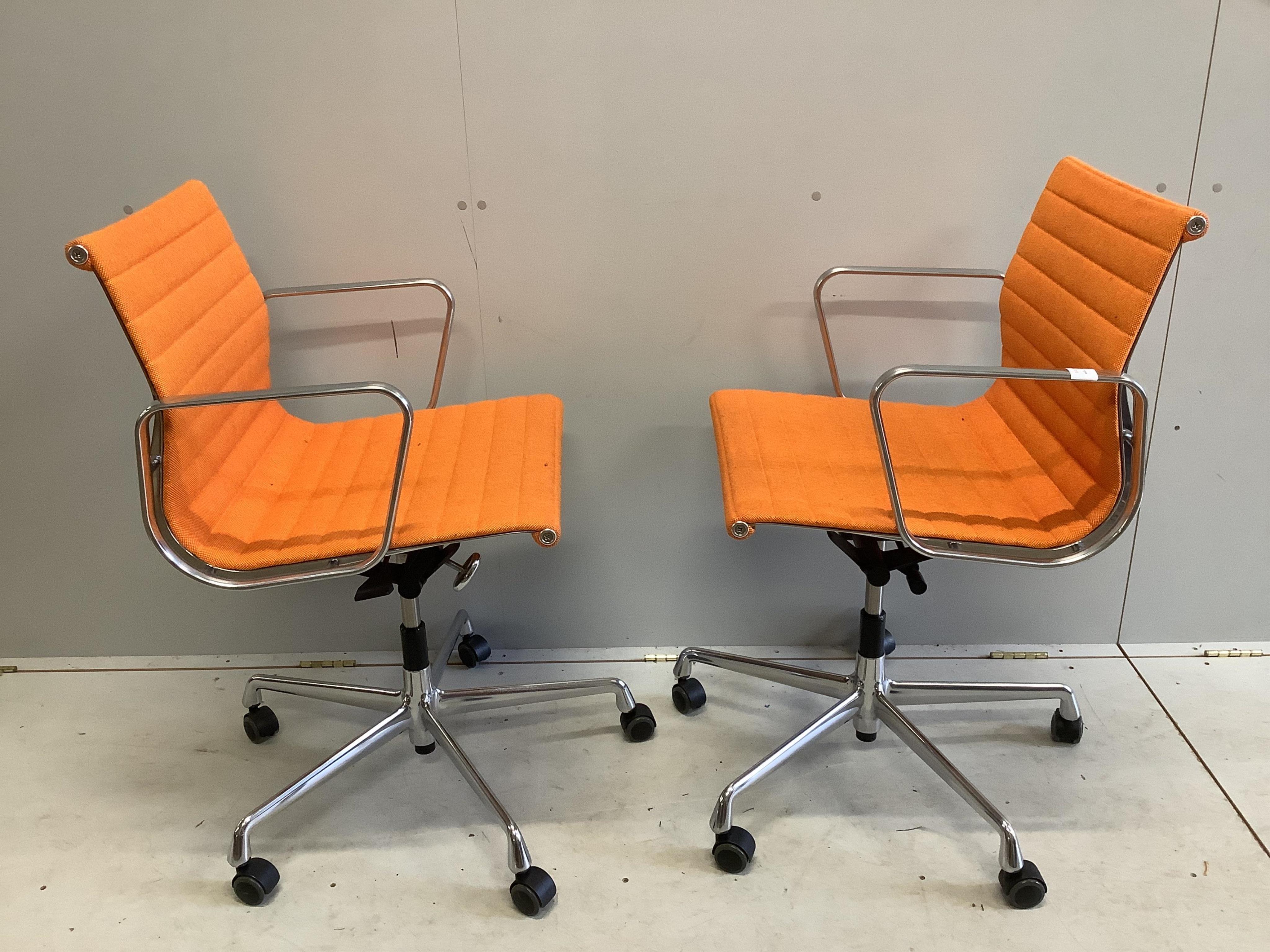 A pair of Vitra Eames EA117 orange fabric office chairs, width 57cm, depth 52cm, height 89cm. Condition - fair to good